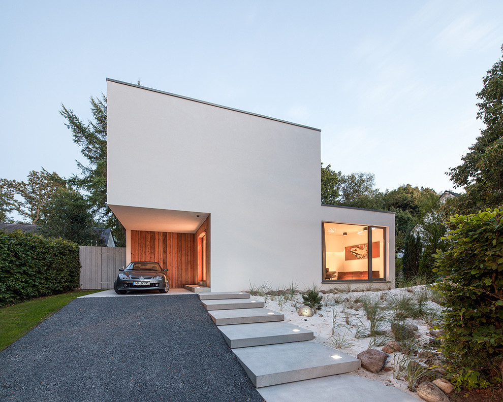 Стильный дизайн: маленький, двухэтажный, белый частный загородный дом в стиле модернизм с облицовкой из цементной штукатурки и плоской крышей для на участке и в саду - последний тренд