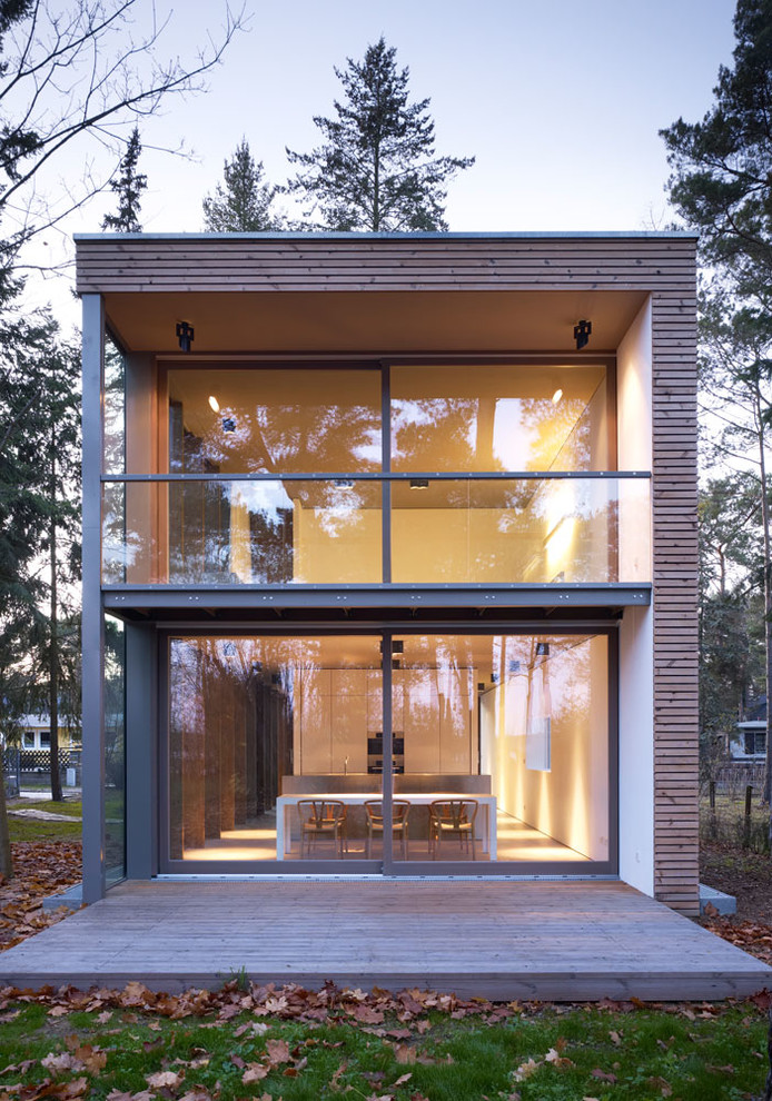 Modelo de fachada marrón moderna de tamaño medio de dos plantas con revestimientos combinados y tejado plano