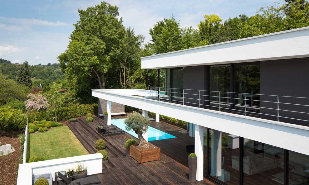 Идея дизайна: двухэтажный, разноцветный дом в стиле модернизм с плоской крышей и облицовкой из цементной штукатурки