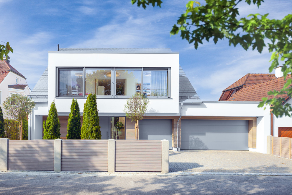 Zweistöckiges, Mittelgroßes Modernes Einfamilienhaus mit Putzfassade, weißer Fassadenfarbe, Flachdach und Schindeldach in Stuttgart