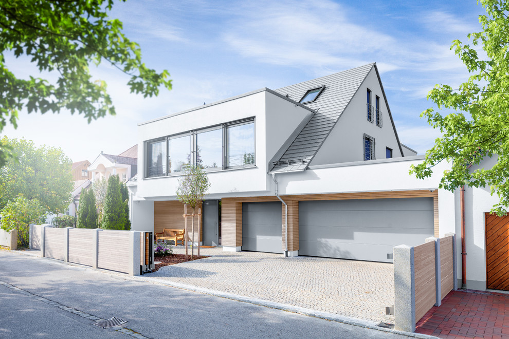 Mittelgroßes, Dreistöckiges Modernes Einfamilienhaus mit Mix-Fassade, weißer Fassadenfarbe, Schindeldach und Satteldach in Stuttgart