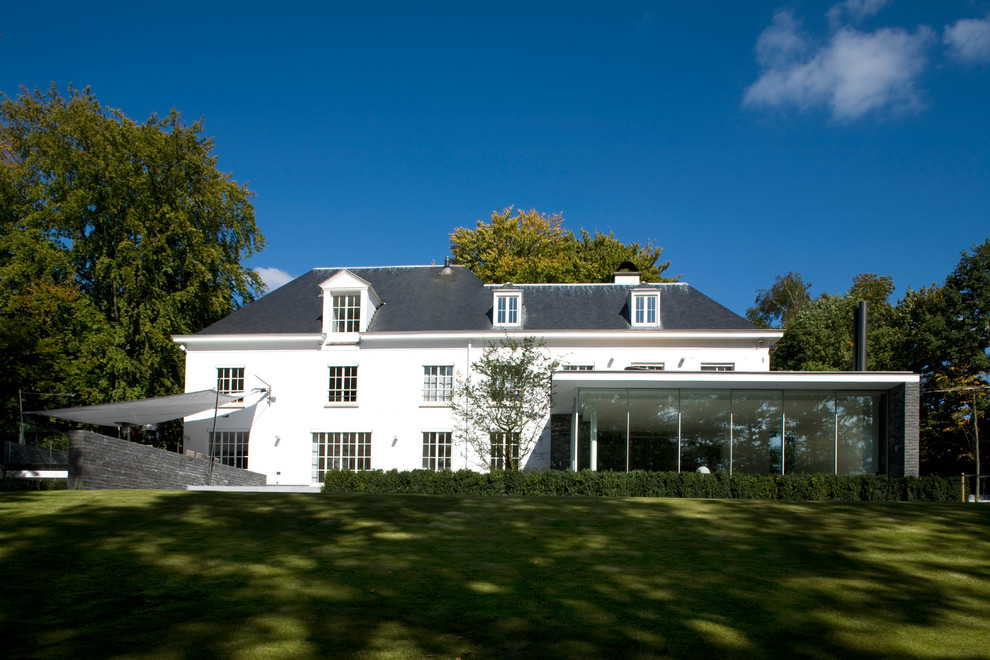Exempel på ett mycket stort modernt vitt hus, med tre eller fler plan, stuckatur, sadeltak och tak i shingel