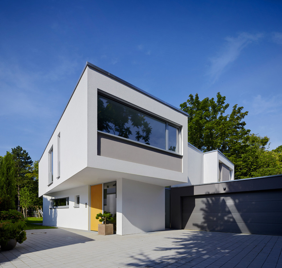 Cette photo montre une grande façade de maison blanche tendance à un étage avec un toit plat.