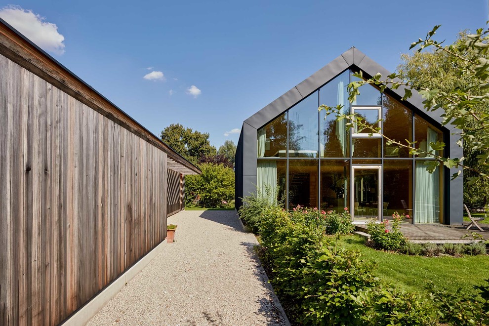 Zweistöckiges Modernes Einfamilienhaus mit grauer Fassadenfarbe und Satteldach in München