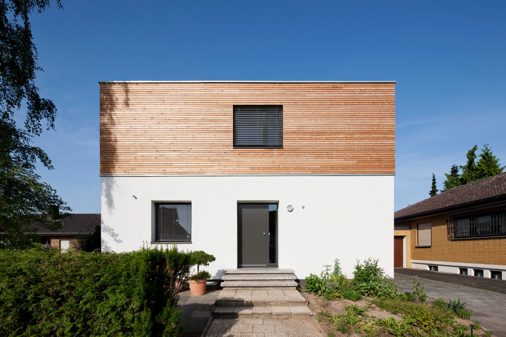 Diseño de fachada marrón actual de tamaño medio de dos plantas con tejado plano y revestimiento de madera