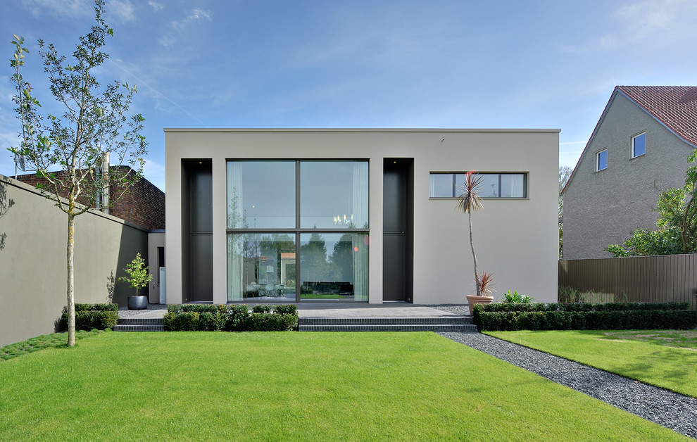 На фото: двухэтажный, серый дом среднего размера в стиле модернизм с плоской крышей с