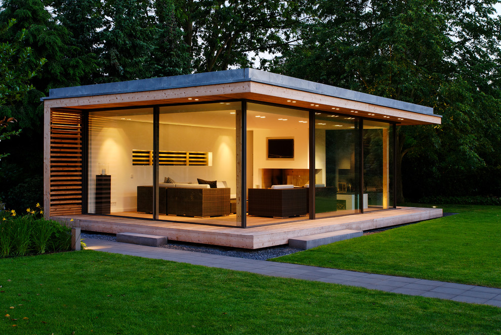 На фото: стеклянный, маленький, одноэтажный дом в современном стиле с плоской крышей для на участке и в саду