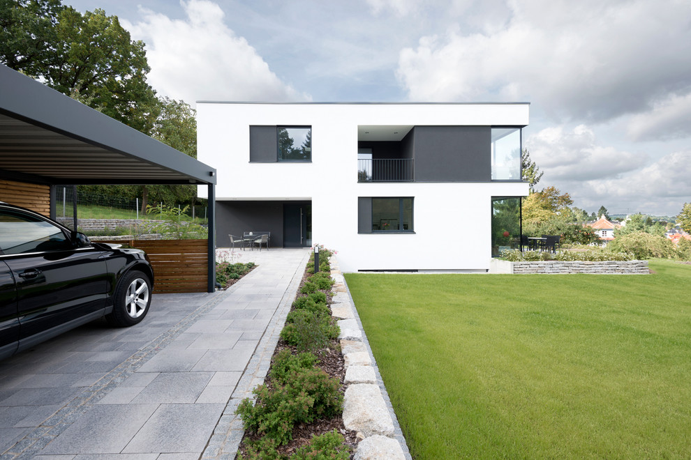 Cette image montre une façade de maison blanche design en stuc à un étage avec un toit plat.