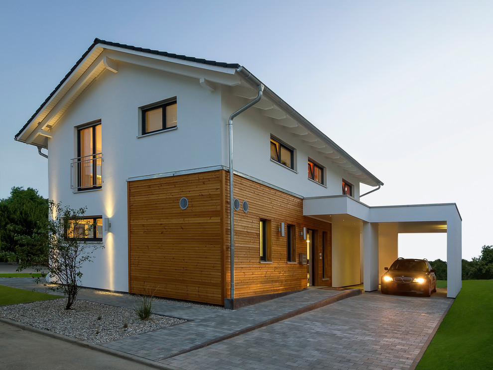 Foto de fachada de casa blanca actual de tamaño medio de dos plantas con revestimientos combinados, tejado a dos aguas y tejado de teja de madera
