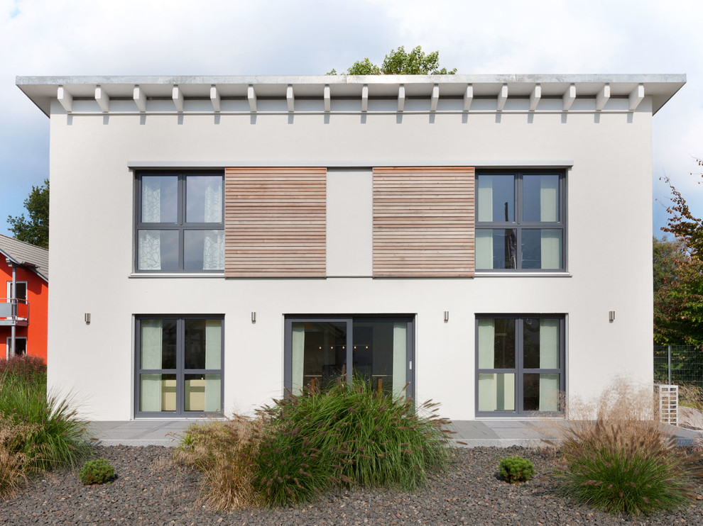 Diseño de fachada de casa beige clásica renovada de tamaño medio de dos plantas con revestimiento de estuco, tejado de un solo tendido y techo verde