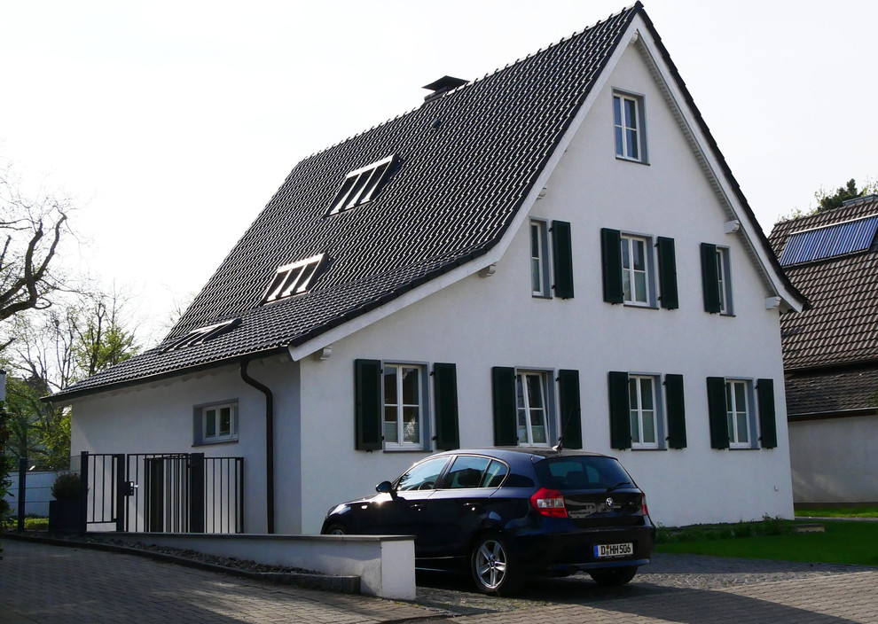 Diseño de fachada de casa blanca contemporánea de tamaño medio de tres plantas con revestimiento de estuco, tejado a dos aguas y tejado de teja de barro