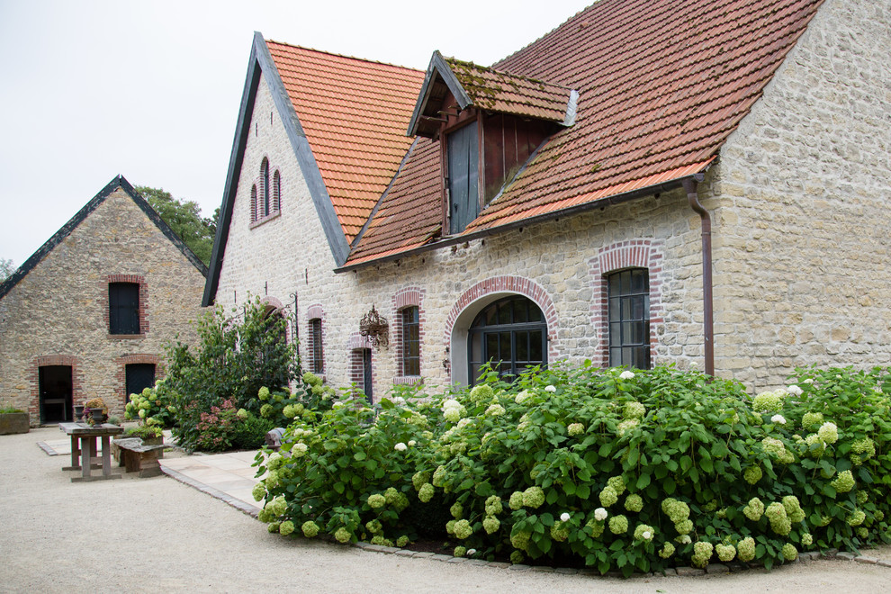 Großes, Dreistöckiges Country Einfamilienhaus mit Backsteinfassade, beiger Fassadenfarbe, Satteldach und Ziegeldach in Sonstige