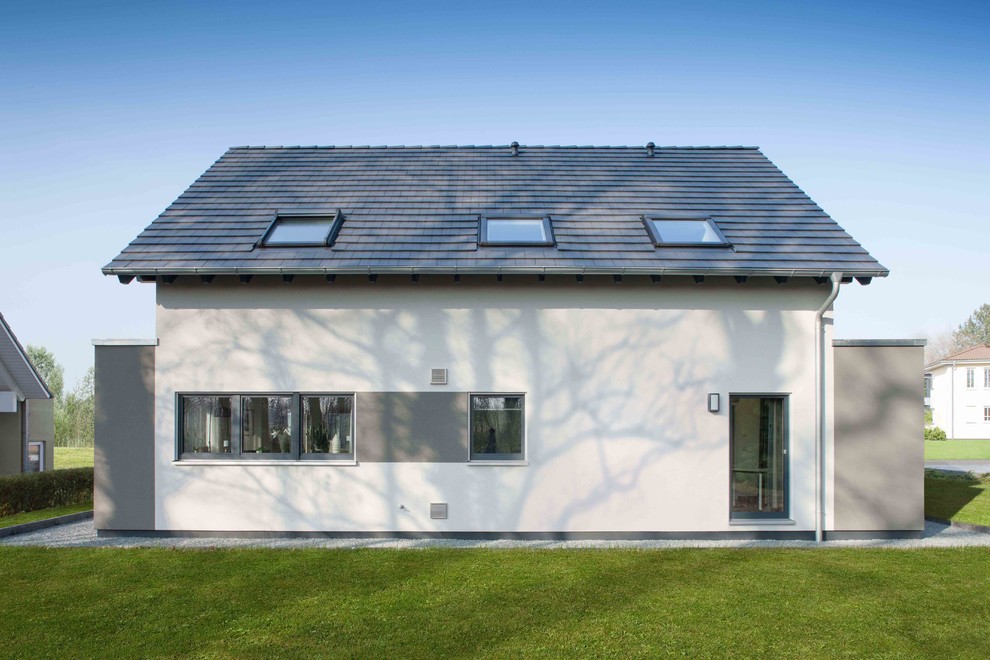 Inspiration pour une façade de maison blanche traditionnelle en stuc à un étage avec un toit à deux pans et un toit en tuile.