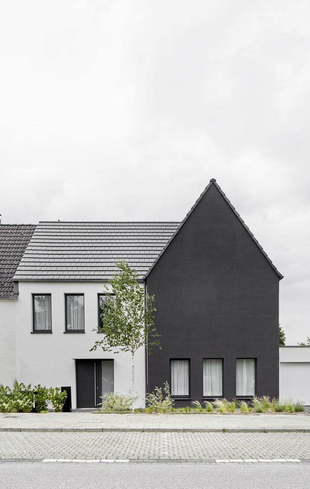 Diseño de fachada de casa negra minimalista con revestimiento de estuco, tejado a dos aguas y tejado de teja de barro