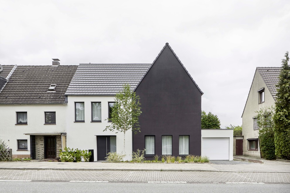 Réalisation d'une façade de maison grise nordique à un étage avec un toit à deux pans.