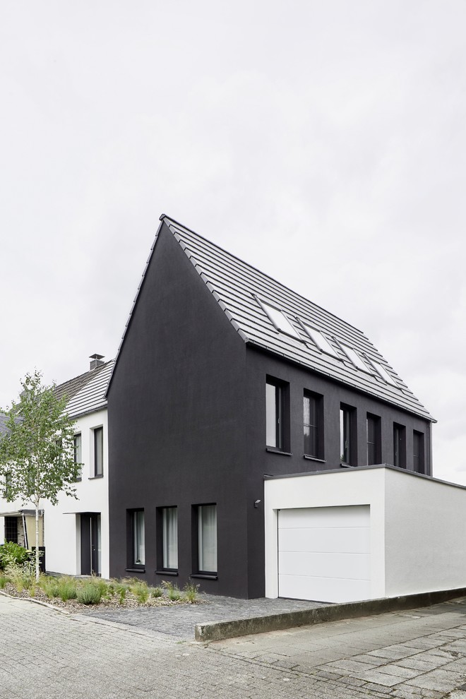 Inredning av ett modernt svart hus, med stuckatur, sadeltak och tak med takplattor