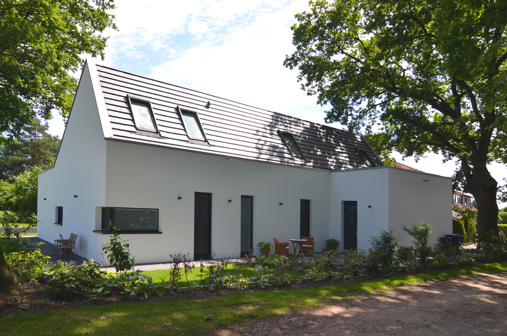 Свежая идея для дизайна: маленький, двухэтажный, белый дом в современном стиле с двускатной крышей для на участке и в саду - отличное фото интерьера