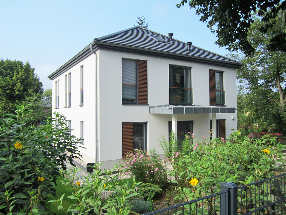 Стильный дизайн: двухэтажный, белый дом среднего размера в современном стиле с вальмовой крышей - последний тренд