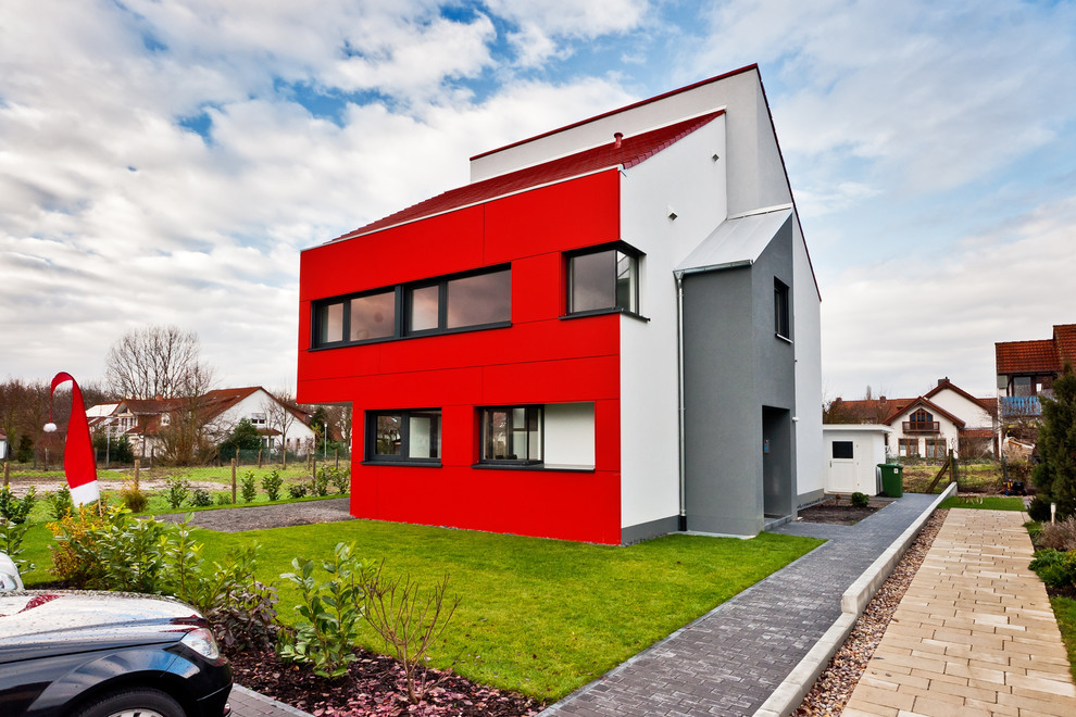 На фото: большой, красный, двухэтажный дом в современном стиле с односкатной крышей и комбинированной облицовкой