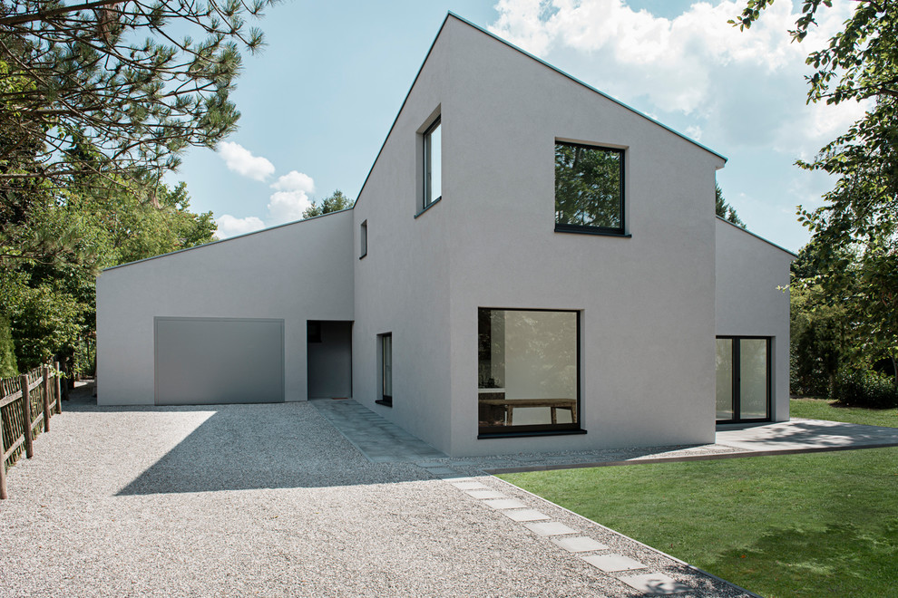 На фото: двухэтажный, серый дом среднего размера в современном стиле с односкатной крышей с