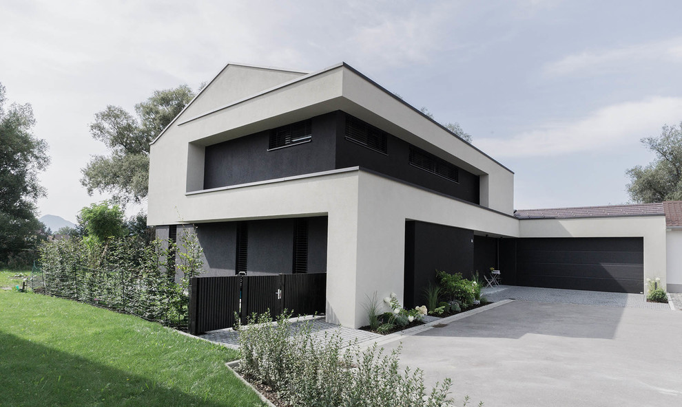 На фото: большой, двухэтажный, разноцветный частный загородный дом в стиле модернизм с комбинированной облицовкой