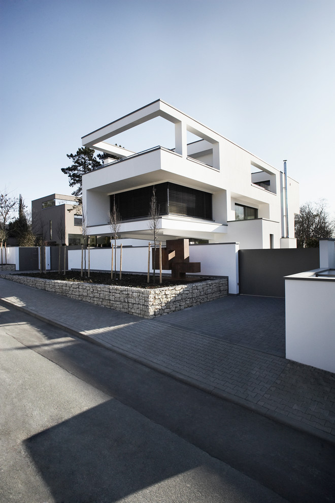 На фото: трехэтажный, белый дом среднего размера в современном стиле с плоской крышей и облицовкой из бетона