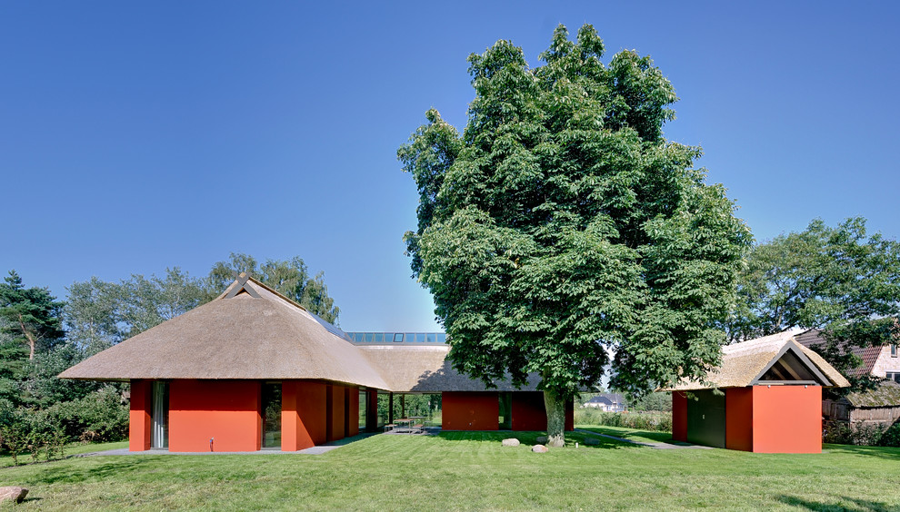 Modern inredning av ett mellanstort rött hus, med allt i ett plan och valmat tak