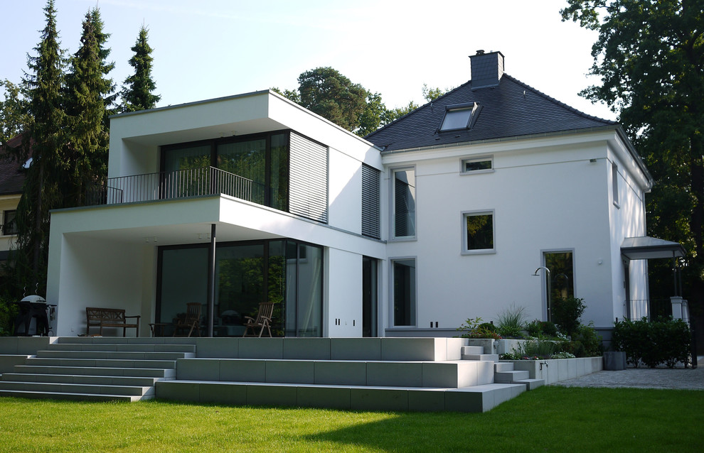 Immagine della facciata di una casa grande bianca contemporanea a due piani con tetto a padiglione