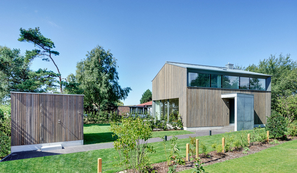 Zweistöckige, Mittelgroße Moderne Holzfassade Haus mit Satteldach und brauner Fassadenfarbe in Berlin