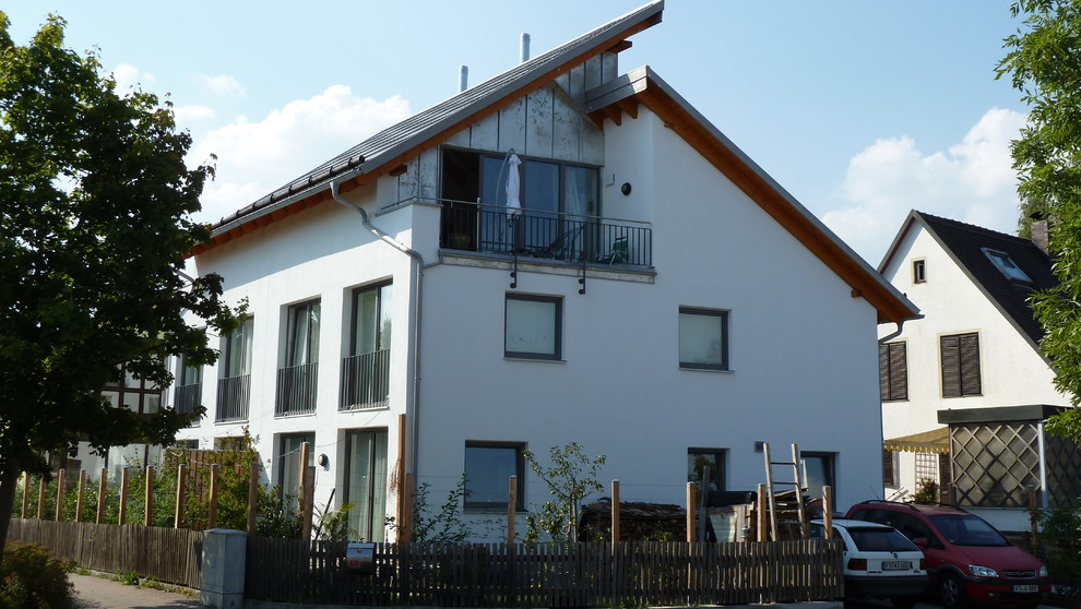 Esempio della casa con tetto a falda unica bianco moderno a tre piani di medie dimensioni con rivestimento in stucco