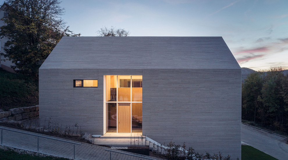 Inspiration pour une façade de maison beige minimaliste en bois de taille moyenne et à un étage avec un toit à deux pans.