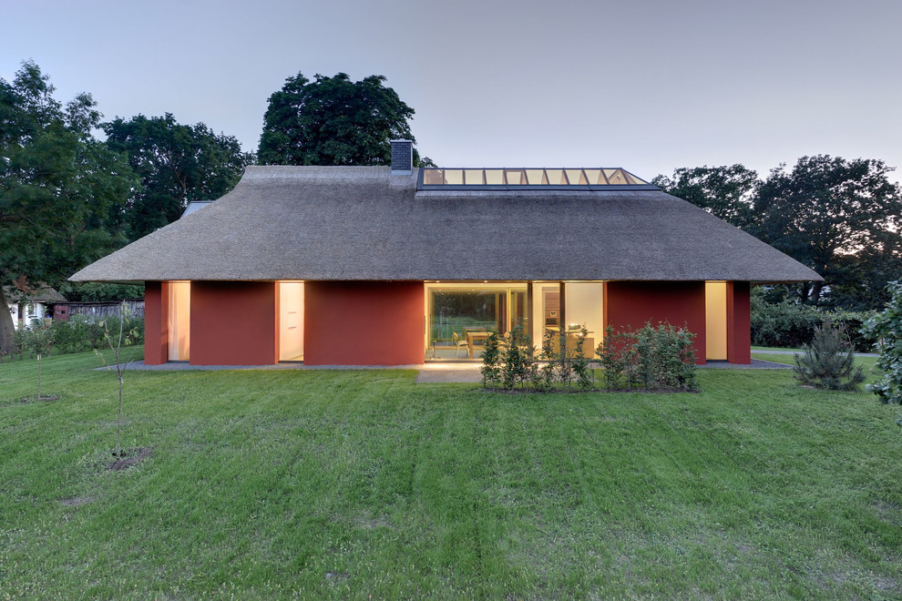 Пример оригинального дизайна: красный, маленький, двухэтажный дом в современном стиле с вальмовой крышей для на участке и в саду