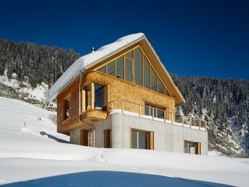 Zweistöckiges Modernes Haus mit Mix-Fassade, brauner Fassadenfarbe und Satteldach in Sonstige