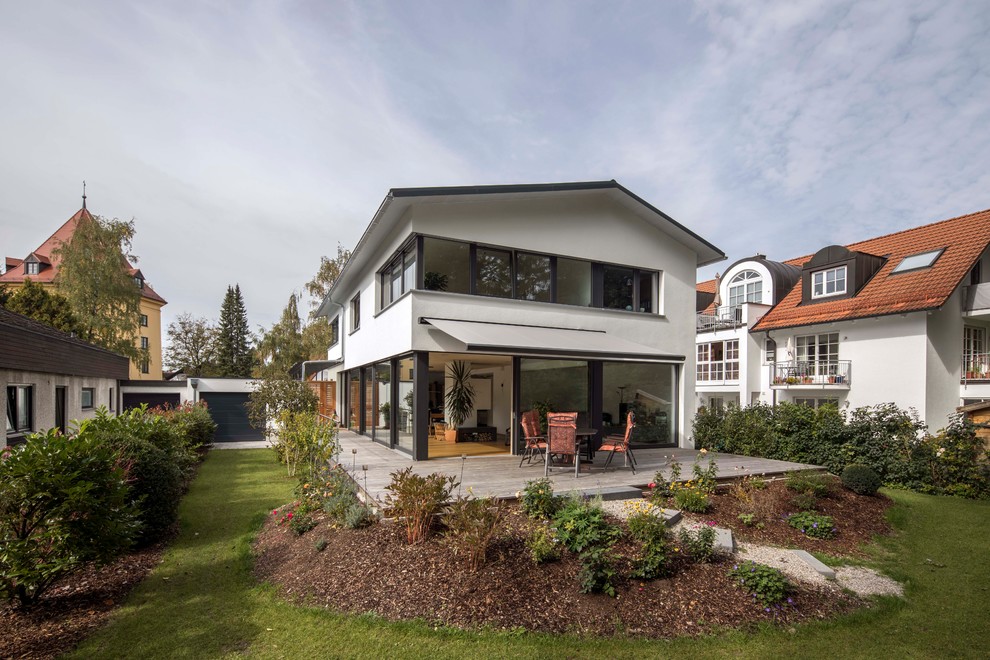 Großes Modernes Einfamilienhaus mit Putzfassade, weißer Fassadenfarbe und Satteldach in München