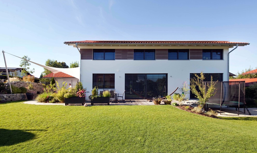 Diseño de fachada de casa roja contemporánea de tamaño medio de dos plantas con revestimientos combinados, tejado de teja de barro y tejado a dos aguas