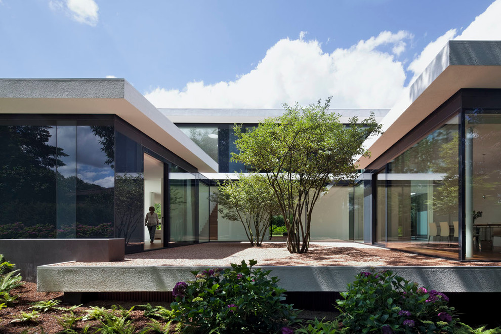 Réalisation d'une grande façade de maison design à un étage avec un toit plat.