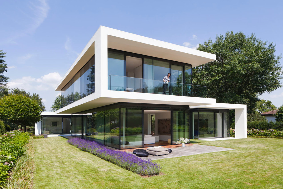 Idée de décoration pour une grande façade de maison design à un étage avec un toit plat.