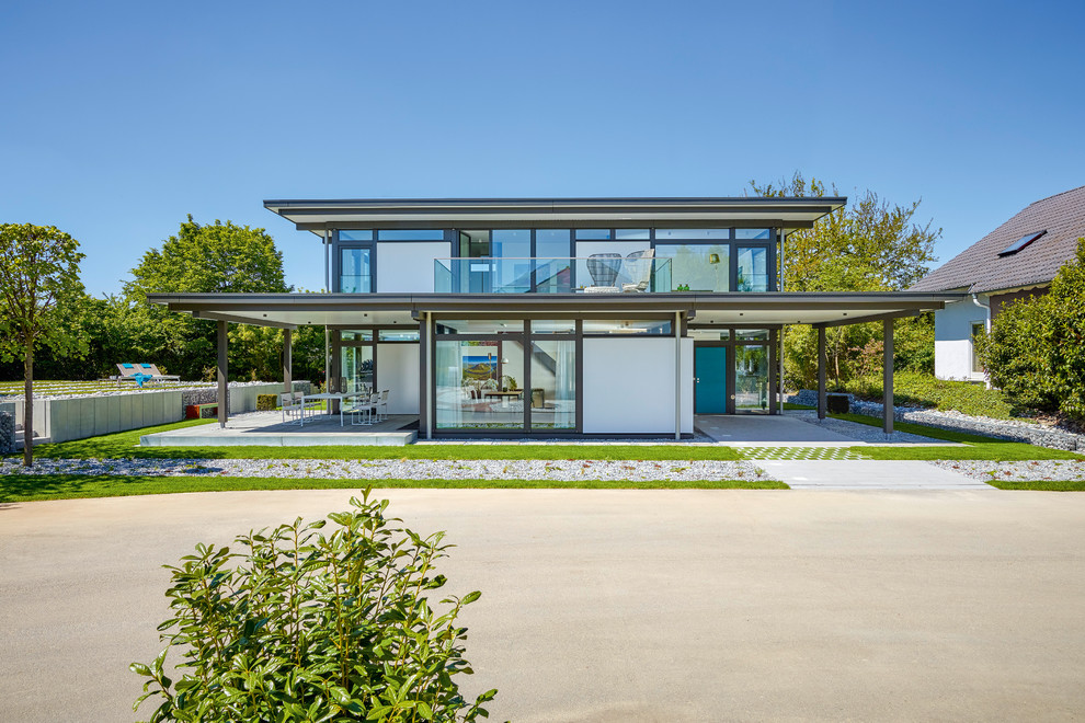 Imagen de fachada de casa gris contemporánea grande de dos plantas con revestimiento de madera y tejado plano