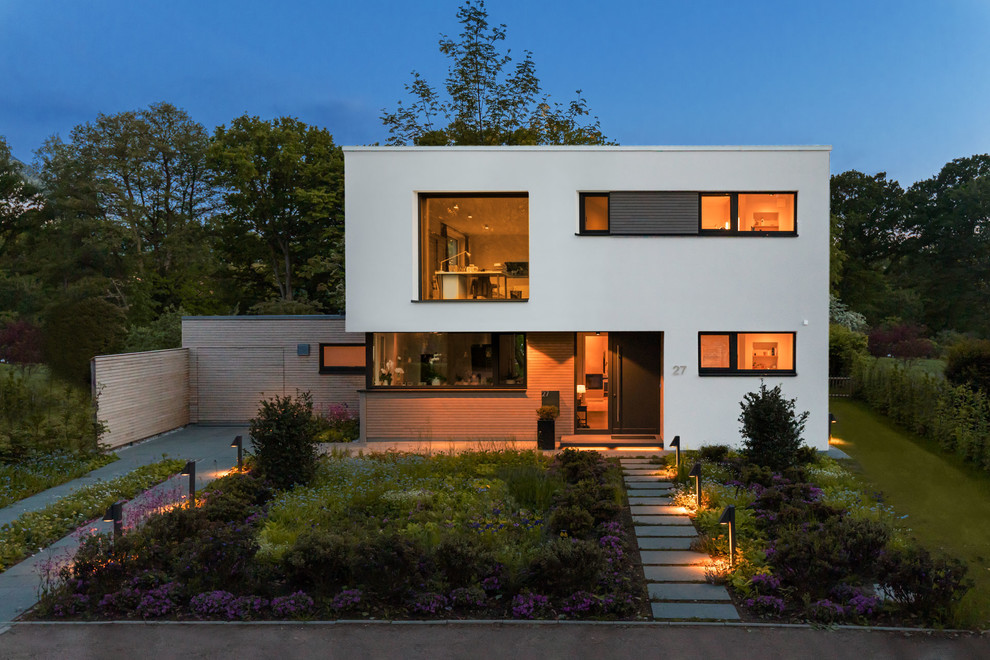 Mid-sized trendy gray one-story stucco exterior home photo in Hamburg with a tile roof