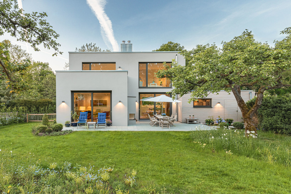 Свежая идея для дизайна: одноэтажный, серый частный загородный дом среднего размера в современном стиле с облицовкой из цементной штукатурки, плоской крышей и черепичной крышей - отличное фото интерьера