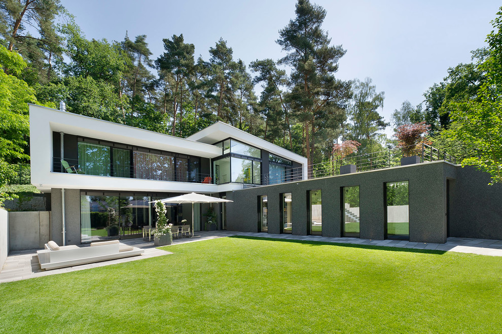 Réalisation d'une façade de maison grise minimaliste à un étage et de taille moyenne avec un revêtement mixte et un toit en appentis.