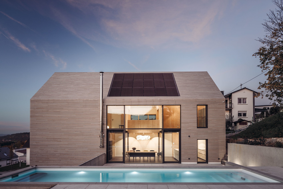 Réalisation d'une façade de maison beige nordique en bois à un étage et de taille moyenne avec un toit à deux pans.