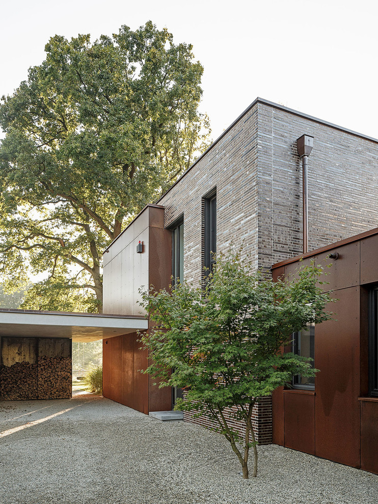 Medium sized and brown contemporary two floor detached house in Cologne with mixed cladding and a flat roof.