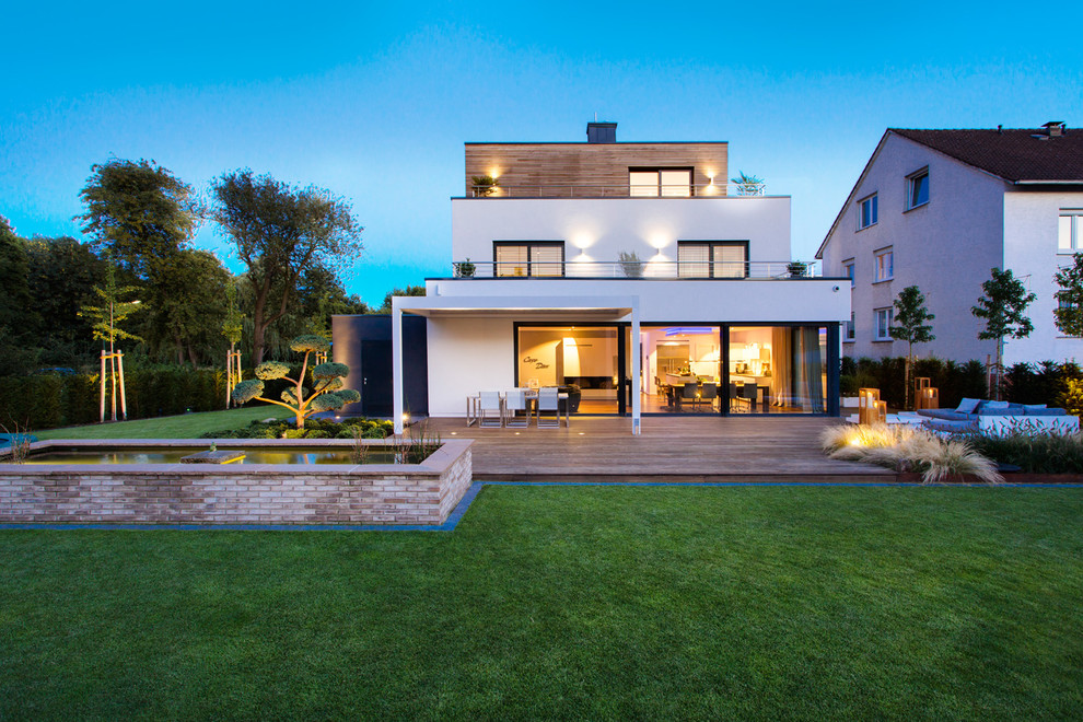 Großes, Dreistöckiges Modernes Einfamilienhaus mit Mix-Fassade, weißer Fassadenfarbe und Flachdach in Sonstige