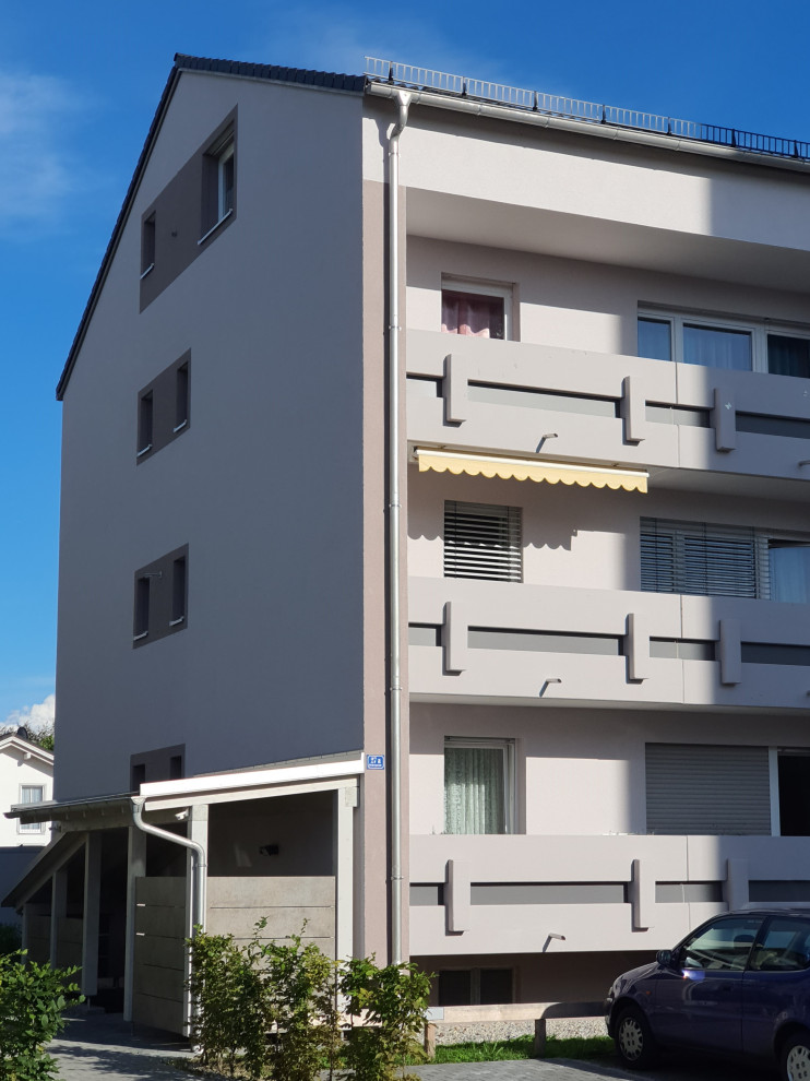 Kleines, Vierstöckiges Klassisches Wohnung mit Putzfassade, grauer Fassadenfarbe, Satteldach und Ziegeldach in München