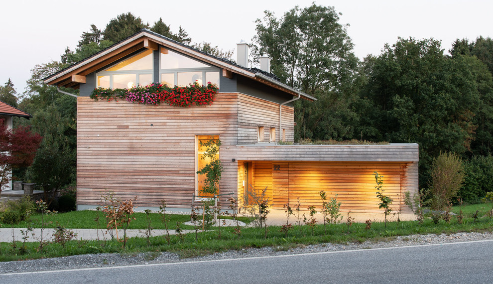 Réalisation d'une façade de maison marron nordique en bois de taille moyenne et à niveaux décalés avec un toit à deux pans et un toit en tuile.