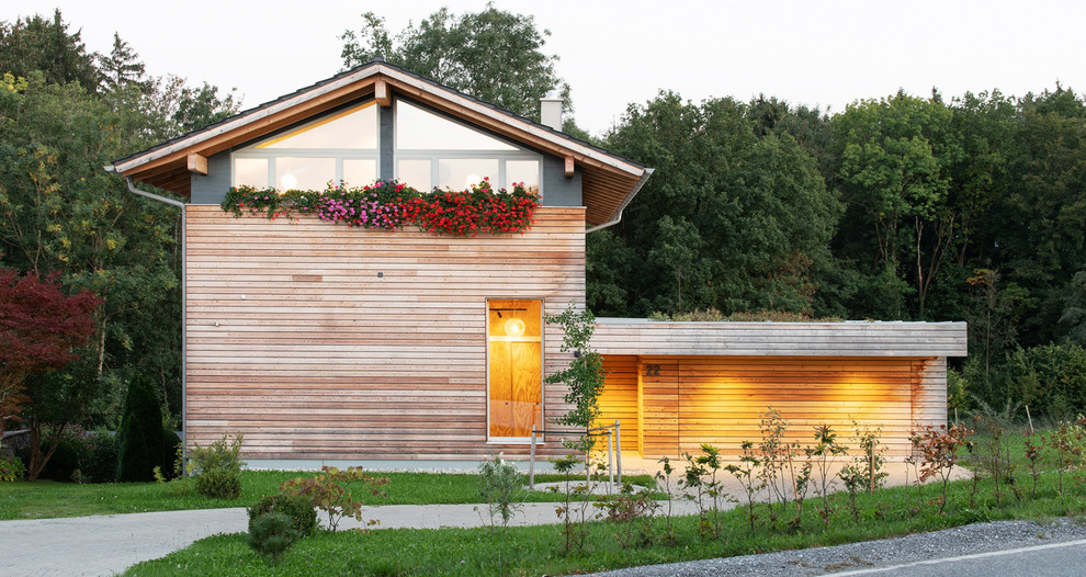 Diseño de fachada de casa escandinava de tamaño medio a niveles con revestimiento de madera, tejado a dos aguas y tejado de teja de barro