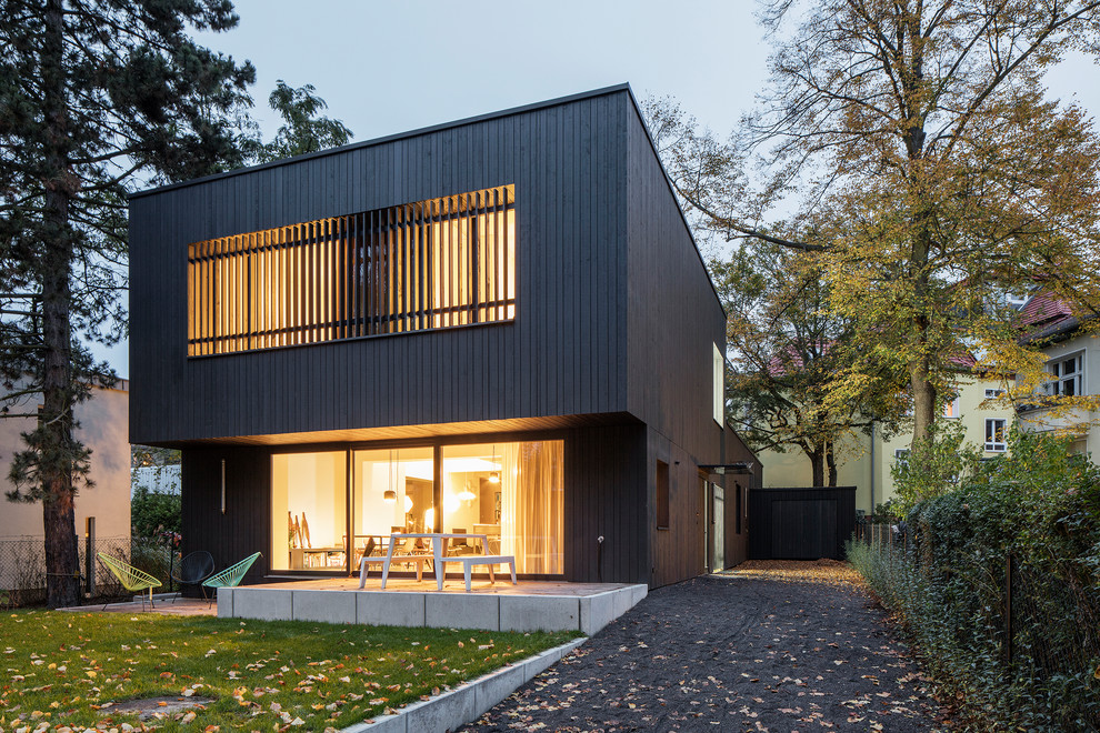 Inspiration för mellanstora moderna bruna hus, med två våningar och platt tak