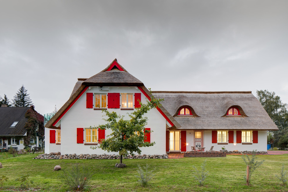 Foto de fachada de casa blanca campestre de dos plantas con tejado a dos aguas