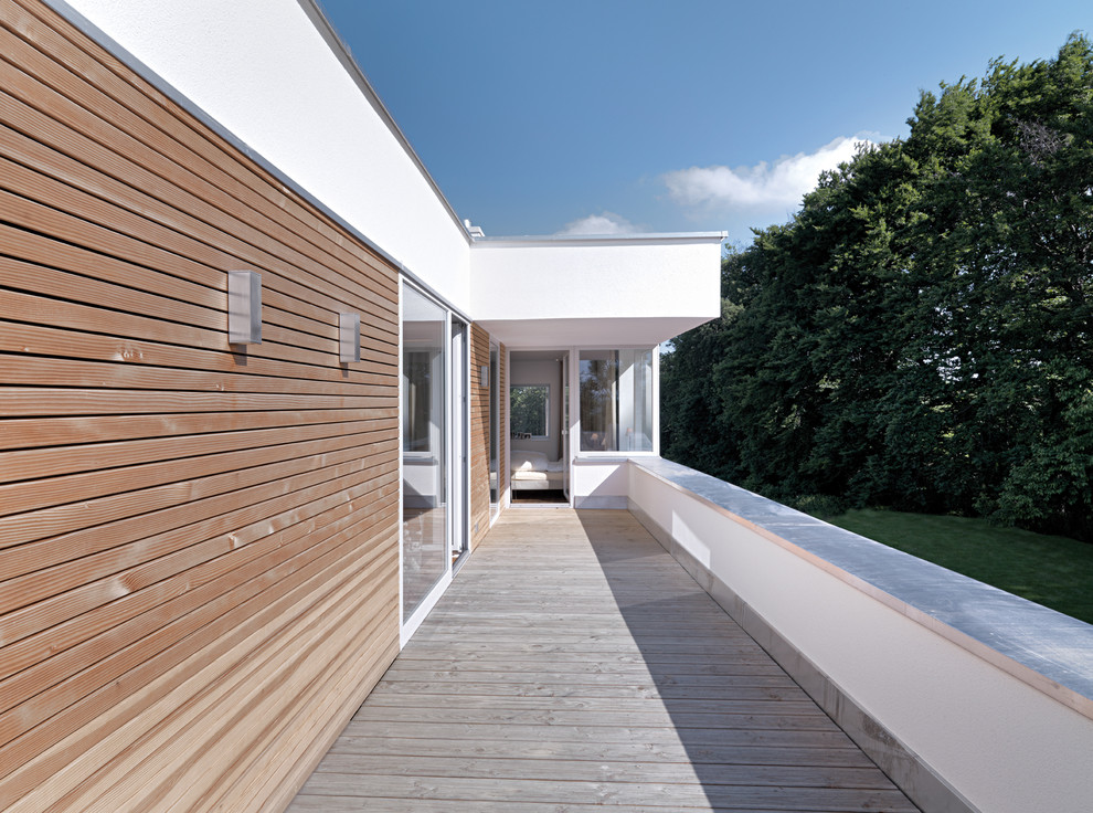 Imagen de fachada blanca actual con revestimiento de madera y tejado plano